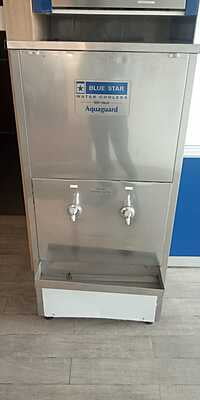 Modern office setting with the Blue Star Water Cooler SWCSDLX6080UVROE positioned in the corner. Modern office setting with the Blue Star Water Cooler SWCSDLX6080UVROE positioned in the corner.