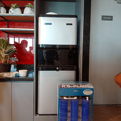 Blue Star Water Cooler P6080E-SL (Standard) with a person using the hot water dispenser for tea Blue Star Water Cooler P6080E-SL (Standard) with a person using the hot water dispenser for tea
